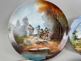 two plates with a painting on them sitting on a table