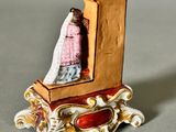 a figurine of a woman sitting on top of a clock