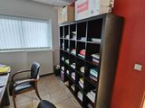 un bureau avec une chaise et une bibliothèque dans un coin