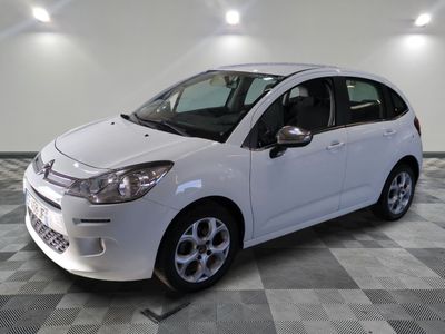 la petite voiture blanche est garée sur un sol en damier