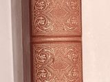 un livre brun posé sur une surface blanche