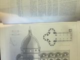an open book with a drawing of a building and a clock on it