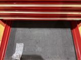 a picture of a red tool bench with a piece of metal