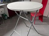 a white table with a red chair in the corner