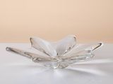 clear glass flower shaped dish on a white surface