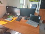 a desk with two computers and a laptop on it