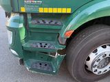 a green semi truck parked on the side of the road