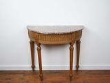 une vieille table en bois avec un plateau en marbre, posée sur un parquet en bois massif