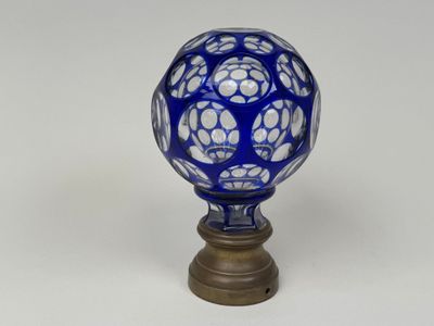 an image of a blue and white glass ball on a wooden base