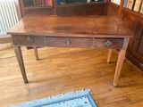 a wooden desk with two drawers and a blue rug