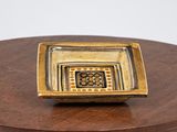 a small square bowl sitting on top of a wooden table