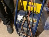 un homme debout à côté d'une charrette contenant des fils électriques