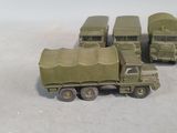 several toy army vehicles are lined up in a row on a white surface