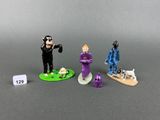 three figurines of a man in a purple suit and a man in a blue suit