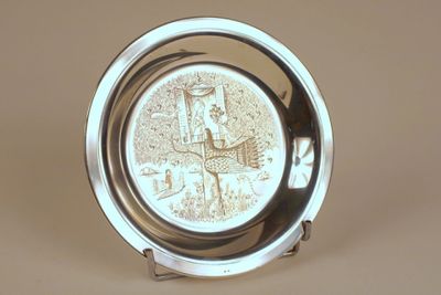 a silver plate with a clock on it on a table