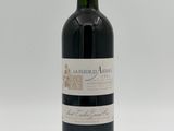 a bottle of red wine sitting on top of a white table