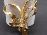 a close up of a gold brooch on a table