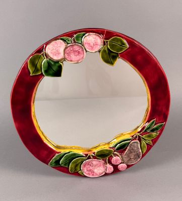 une photo d'un miroir rouge orné de fleurs