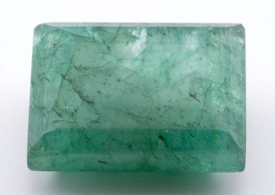 gros plan d'une pierre d'émeraude verte sur une surface blanche