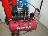 a red air compressor sitting on the floor next to a red fire hydrant