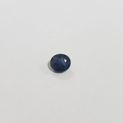 une pierre de saphir bleu sur une surface blanche