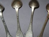 four spoons are lined up on a table with a white background