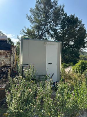 une petite boîte blanche posée au milieu d'un champ