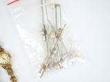 a bunch of pins and a watch on a table