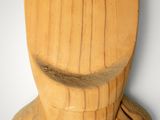 a wooden sculpture of a man ' s head on the wall