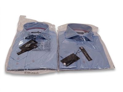 two blue shirts wrapped in plastic bags on a white surface