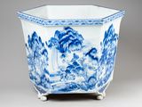 a blue and white vase with a mountain scene on it