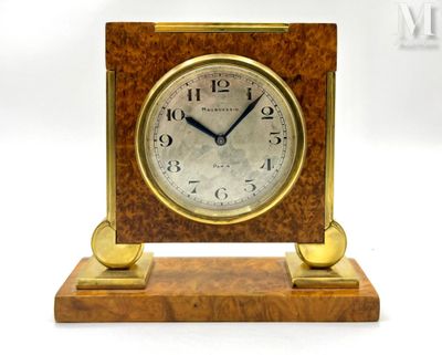a small wooden clock on a stand with a white background