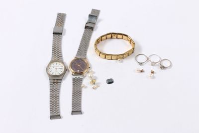 a watch, bracelet, and ring on a white surface