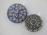 two round glass magnets sitting on top of a white table