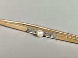 an image of a close up of a gold tie bar with a pearl