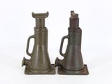 two old style oil pumps sitting on a white surface