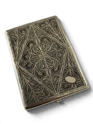 an antique silver cigarette case on a white background