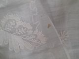 a close up of a white table cloth with a flower design on it