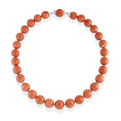 a coral beaded necklace on a white background