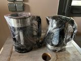 deux tasses emballées dans du film plastique, posées sur une table