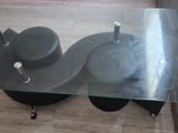 a glass table with wheels on it on the floor