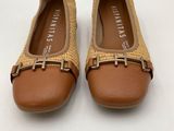 a pair of tan shoes with a gold buckle on the front