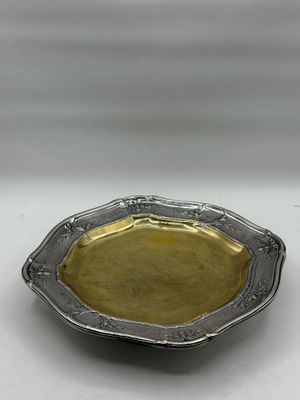 a silver plate with a gold rim on a white surface