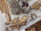 many different types of necklaces and bracelets on a table