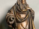 a statue of a man with a beard holding a book