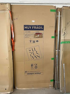 une boîte en carton sur laquelle est accrochée une pancarte, dans une pièce