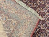 a close up of a rug on the floor with a wooden floor in the background