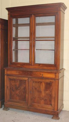 un grand meuble en bois avec des portes en verre dans une pièce