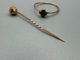 deux bagues en or et une paire de boucles d'oreilles posées sur une surface grise