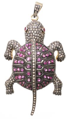 un gros plan d'un pendentif en forme de tortue orné de pierres roses sur fond blanc